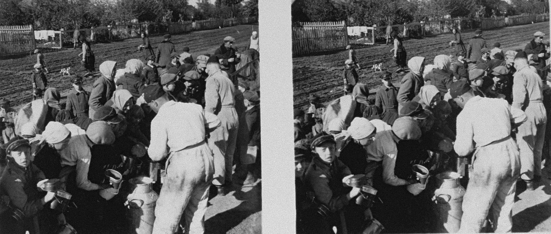 Stereoscopic photograph of Polish civilians receiving food from a special relief train from Bavaria on the outskirts of Warsaw.