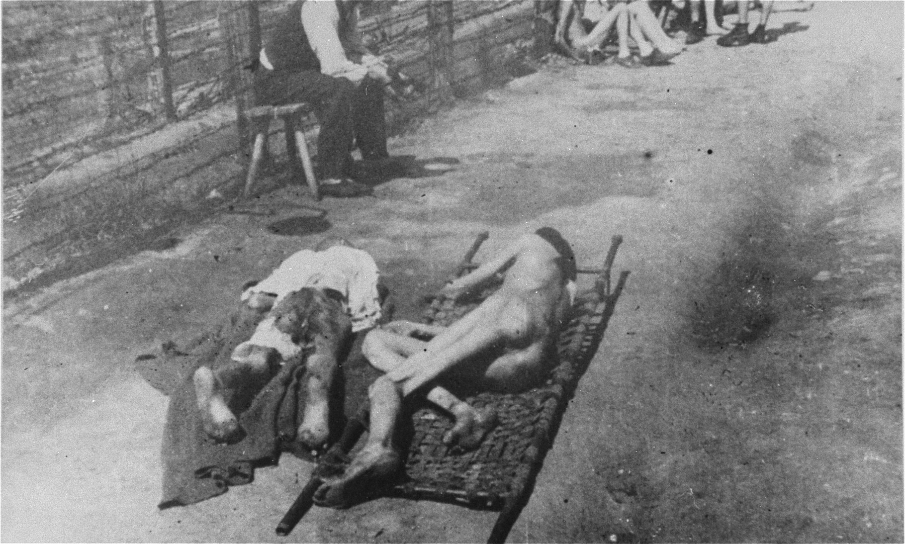 Two bodies lie on stretchers in Mauthausen after liberation.