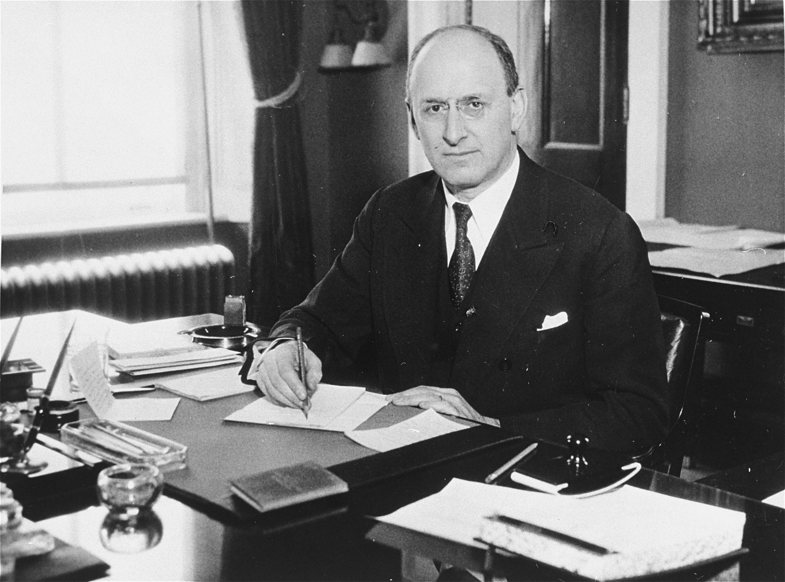 Portrait of Henry Morgenthau Jr. at his desk in the U.S. Department of the Treasury.

Henry Morgenthau Jr. (1891-1967), served as Secretary of the Treasury under Franklin Roosevelt, and as such, was the highest ranking Jewish official in the administration.    In January 1944, after receiving a report prepared by his subordinates on "the acquiescence of this government in the murder of the Jews," Morgenthau wrote a personal report to the President which led to the establishment of the War Refugee Board.   After the war he became Chairman of the United Jewish Appeal and served in that capacity until 1950.