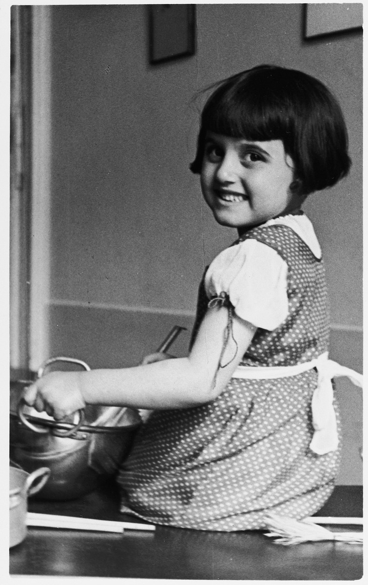 Close-up portrait of Kitty Weichherz helping in the kitchen.

This photo was taken from the diary of Kitty's life written by her father, Bela Weichherz.