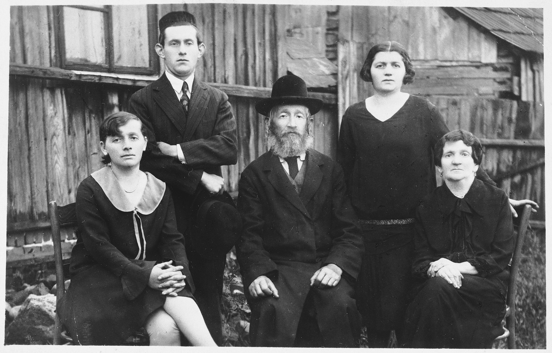 Members of a Jewish family pose outside in Kolbuszowa.

Pictured are Hersh (Sonel) Yaacov and Dobe (Mania) Kornbluth Silber (seated on the right) with their children, Rachel (seated front, left), Mosyc Aaron, and Bracha (standing in back).