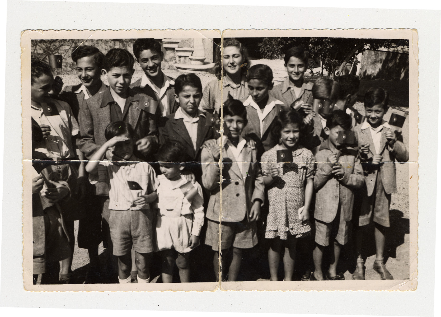 Group portrait of Jewish children in Lisbon where they are waiting to immigrate to the United States.

Manfred Manasse is pictured in the front row shading his eyes.  His brother Gustav is pictured on the far left.