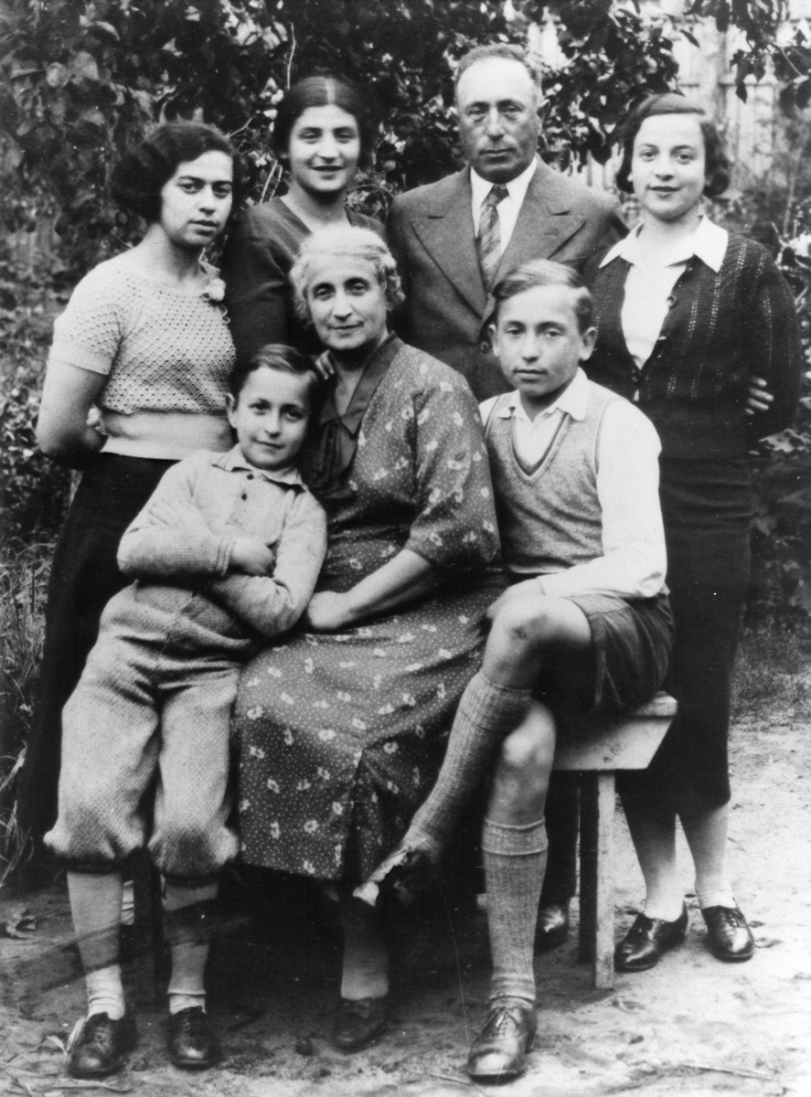 The Birger family poses in a garden in Kaunas. 

Zev is standing in knickers beside his mother Zipporah (Feiga).  His brother Mordecai (b. 1923) is to her right.  Standing from left to right is Bella Chait, Bella Hamburg Adler,Zev's father Pinchas and Rivka Hamburg.

Of those pictured only Zev Birger and Bella Adler survived.