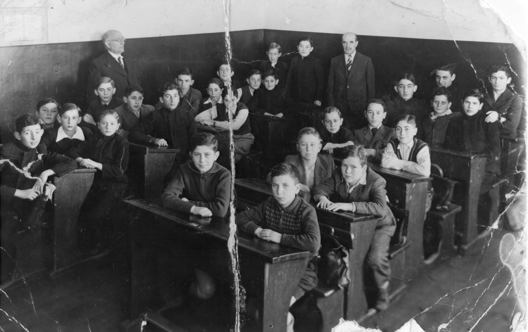 Class of the Real Hebrew Gymnasium, the first Hebrew high school in Kaunas.  

Mr. Dumblansky, the Hebrew teacher, stands in the back of the room.  Those seated include Zev Birger, Fima Strom, Micklishansky, Memko Rubin, and Motke Fischer.