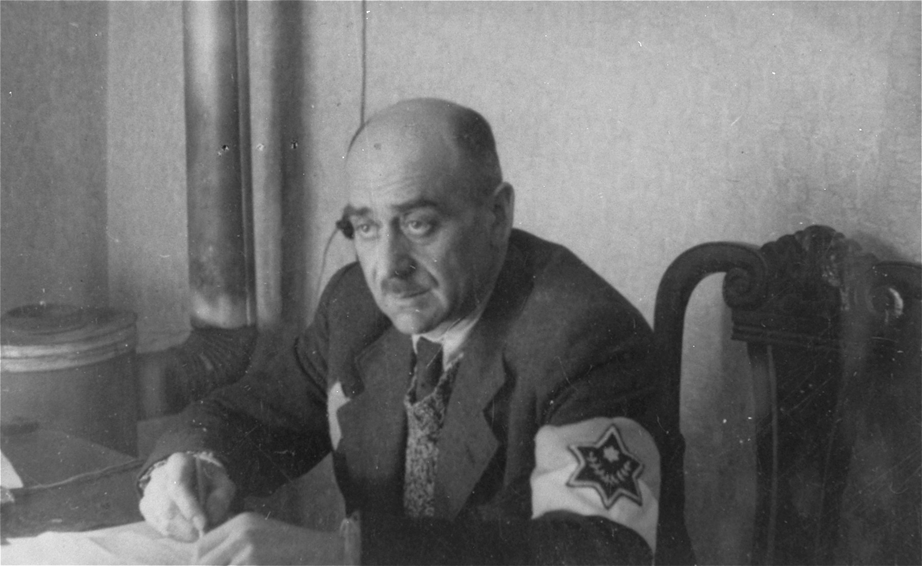 Leon Rozenblat, chief of the ghetto police, is seated in his office in the Lodz ghetto.