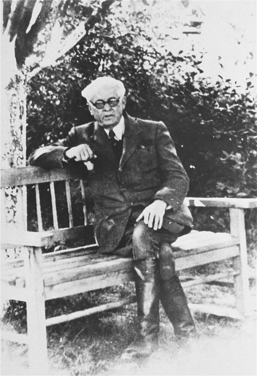 Portrait of Mordechai Chaim Rumkowski, chairman of the Lodz ghetto Jewish Council, seated on a bench.
