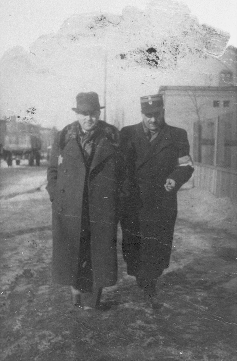 Leon Rozenblat, chief of the Lodz ghetto police (right), walks along a street in the ghetto with an unidentified man.

The other man may be Stanislaw Jacobson, Chief Ghetto judge.