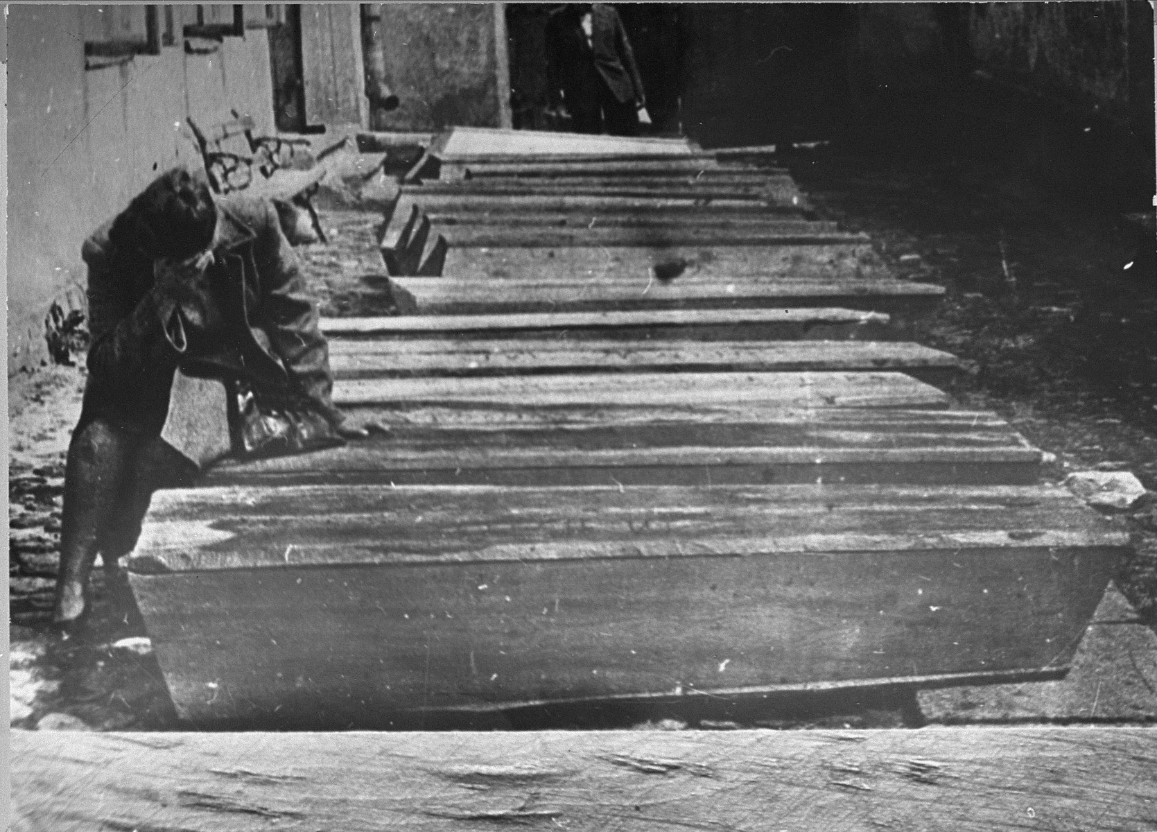 A woman weeps over the coffins of Jews killed during the Kielce pogrom.