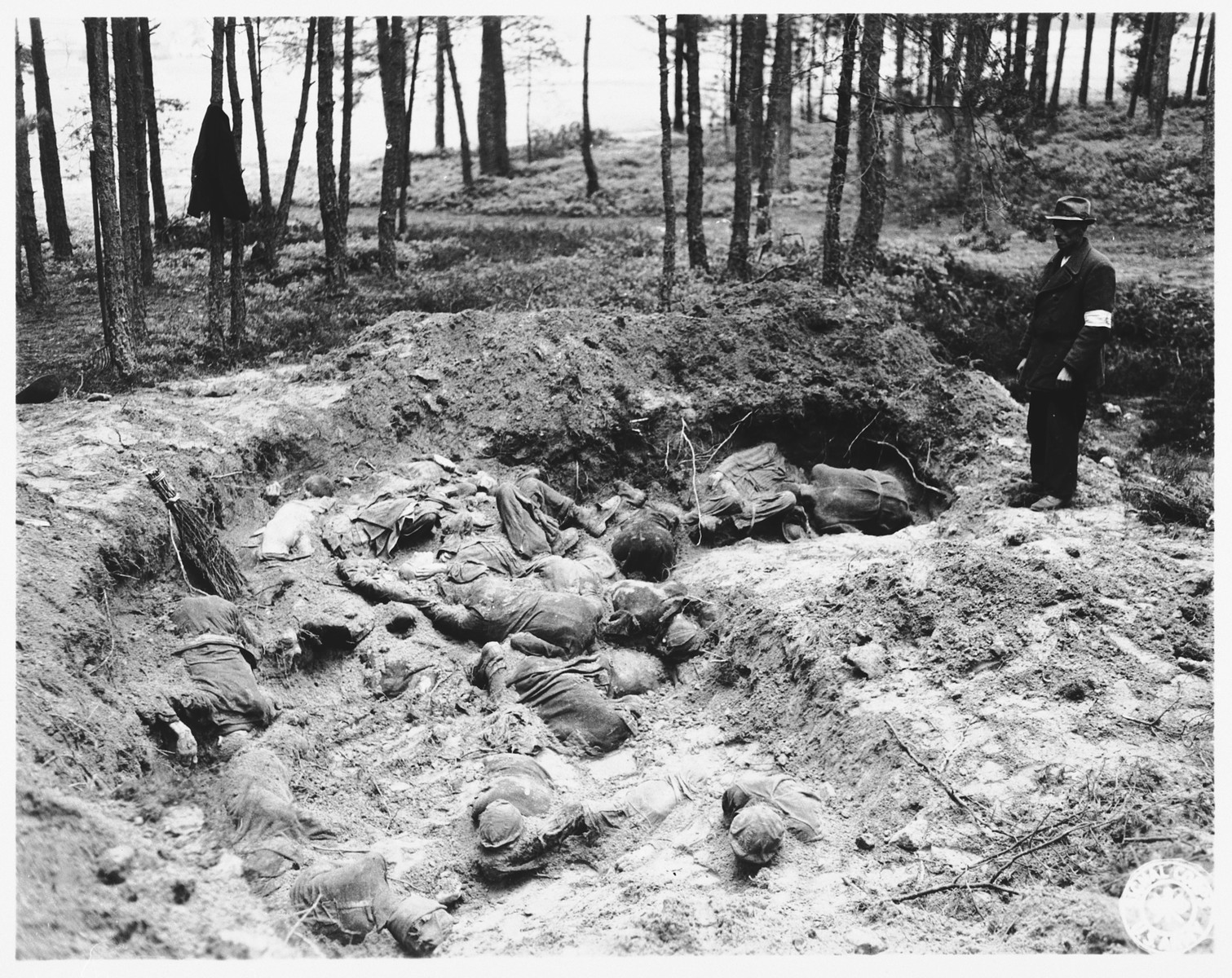 The local Burgomeister views the partially exhumed mass grave in Stamsried, Germany.

(Photograph taken by the 166th Signal Corps Company.)