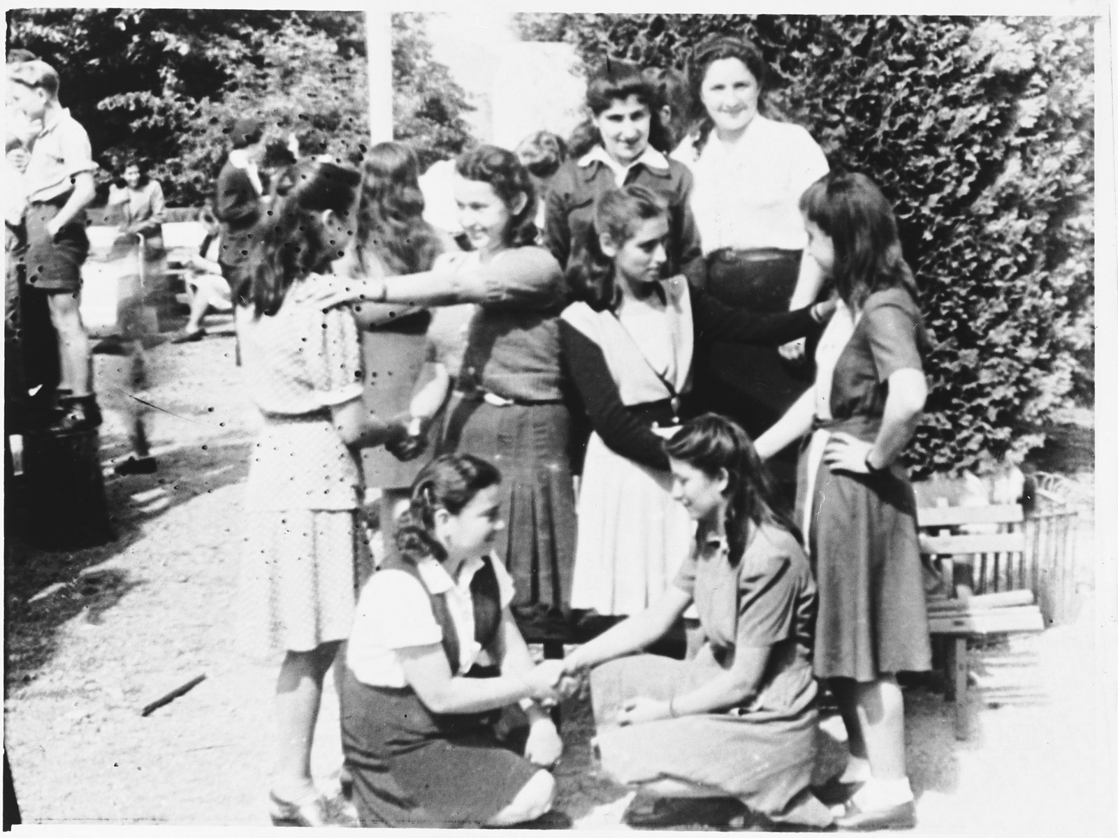 A group of girls shake hands outside the Selvino children's home.
