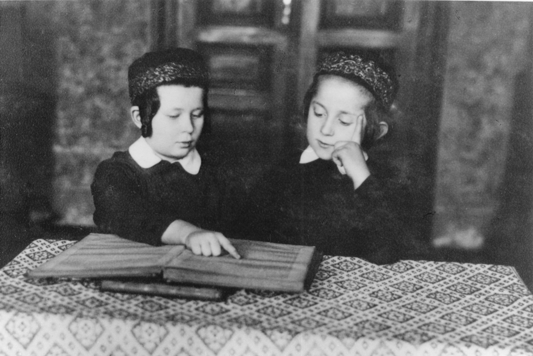 Two young Jewish Hasidic boys study a religious text while seated at a table.

Pictured on the right is Menahem-Mendel Horowitz, the seven-year-old son of Rabbi Tuvia Horowitz.