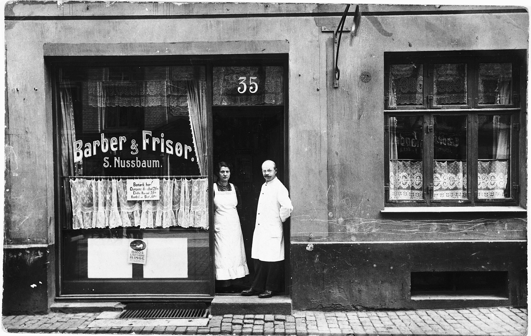 A Jewish couple poses in the doorway of their new barbershop located on the Ochenschlagergade in Copenhagen.

Pictured are Saul and Chane Nussbaum, who live in the same building.