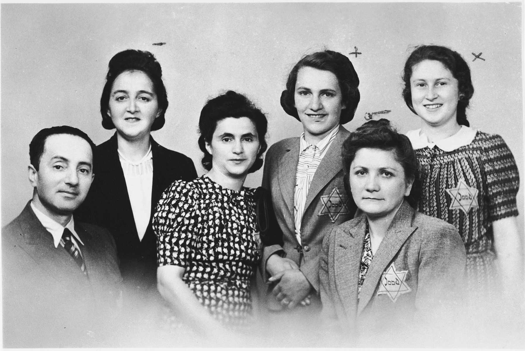 Group portrait of five Jewish women and a Jewish man, wearing Dutch Star of David badges inscribed with the word "Jood".

Pictured from left to right are: Jacob Szwajcer, Regina Malinger, Bajla (Ferens) Szwajcer, Golda Zweifach from Krakow, Klara Ringel from Ukraine and Jadzia Rosen from Warsaw.