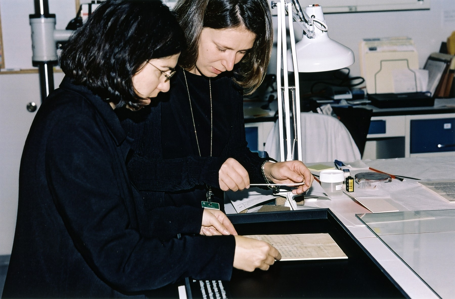 Photo conservator Emily Jacobson and Permanent Exhibition Coordinator Kathleen Mulvaney measure an artifact in the Museum's conservation lab before it is installed in the Permanent Exhibition as part of a regular rotation plan.

The document pictured is the ethical will of Elkhanan Elkes, the chairman of the Kovno ghetto Jewish Council.