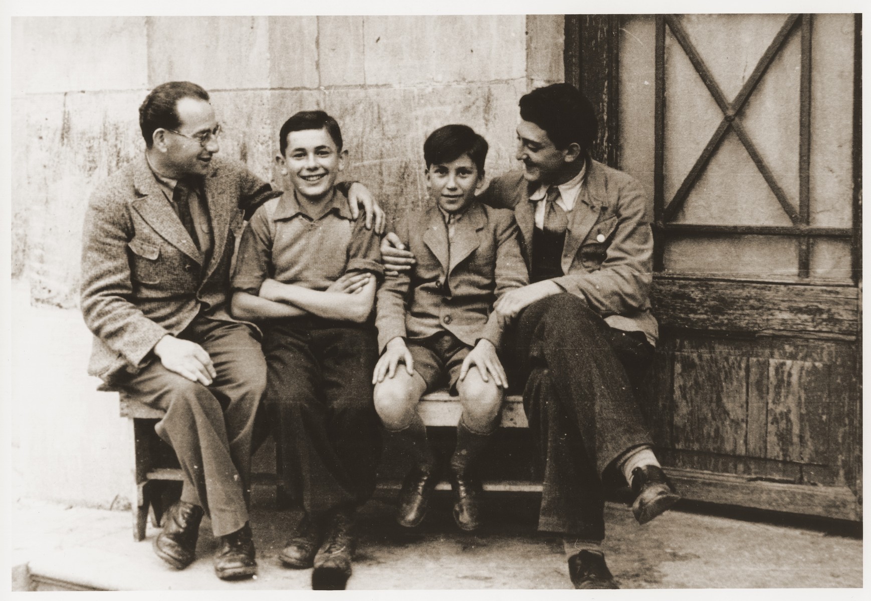 Two Jewish boys sit on a bench with their counselors at the Rothschild's Château Ferrière, where they are attending a summer camp sponsored by the OSE (Oeuvre de secours aux Enfants). 

Pictured from left to right are Manfred Reingewitz, Romek Wajsman, Salek Finkelstein and Ralph Lewin.