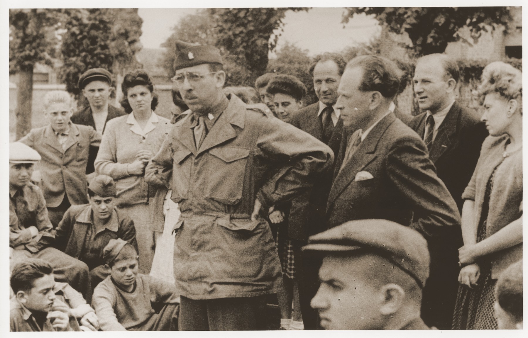 US Army Chaplain Rabbi Morris Dembowitz meets with members of the Buchenwald children's transport outside the Ecouis children's home. 

Among those pictured is Hans Oster (second row of children from the bottom, second from the left).