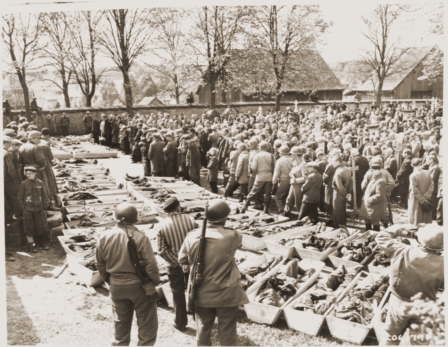 U.S. troops and German civilians from Neunburg vorm Wald attend a funeral service for Polish, Hungarian, and Russian Jews found in the forest near their town.  The victims were shot by the SS while on a death march from Flossenbuerg.

The original caption reads, "At the burial grounds outside Nurnburg, Germany, a prayer was offered in English, Polish, and German for the slave laborers who had been murdered by the Nazis." [sic]