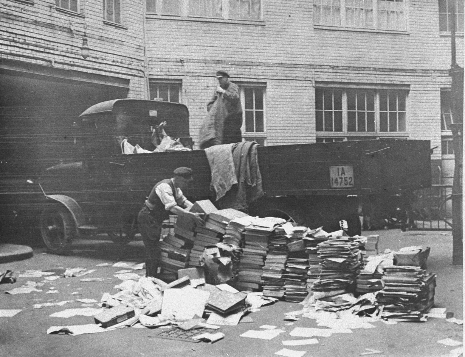 Civilians help load Communist publications onto the back of a truck during a raid of the Karl-Liebknecht House (KPD headquarters), which was on the Buelowplatz in Berlin.  

The closing of Communist Party offices was declared necessary for the protection of the state in the Enabling Act, passed by the Reichstag soon after the fire of 28 February 1933.