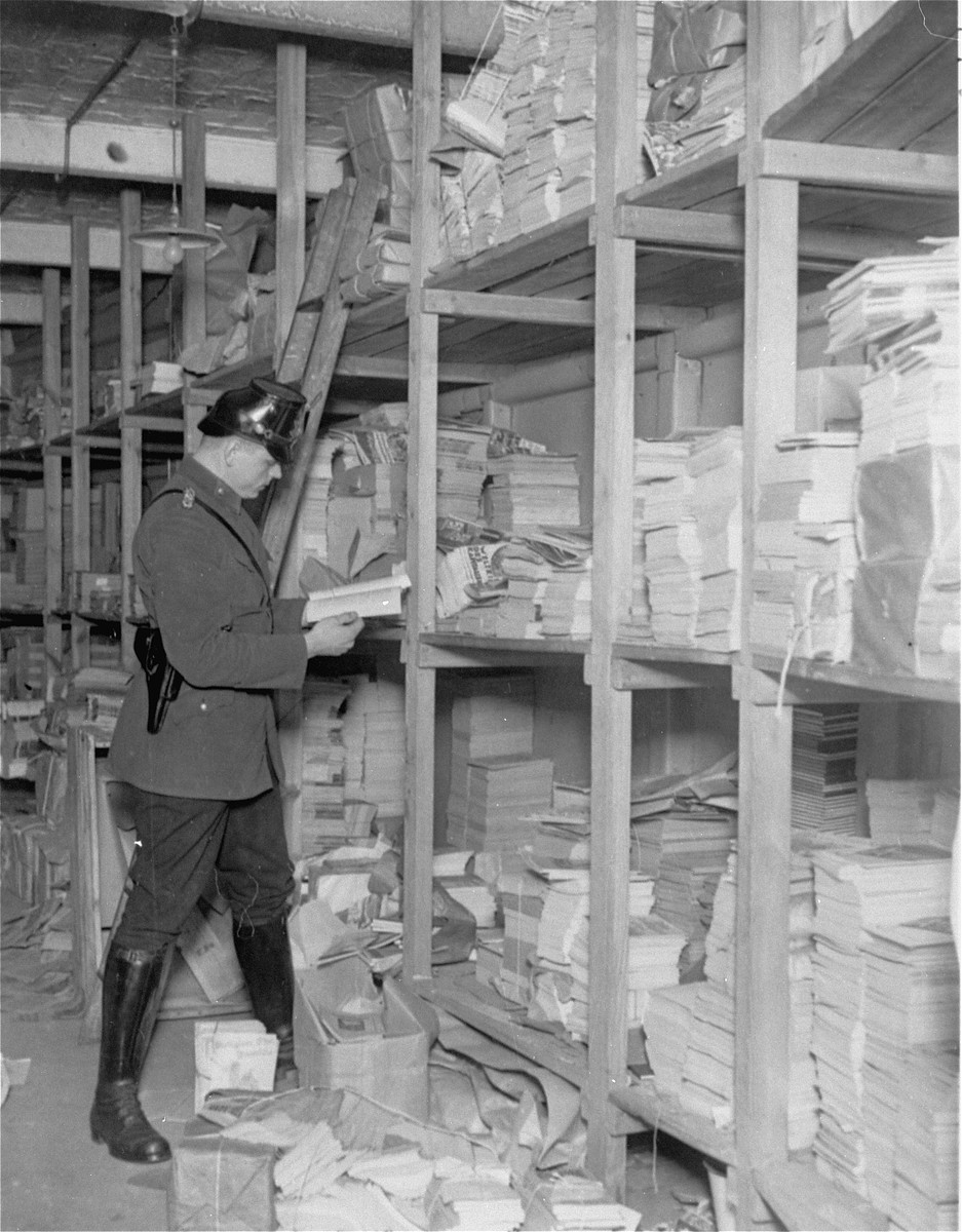A member of the Schutzpolizei looks through publications in a storeroom during the closing of the Karl-Liebknecht House (KPD headquarters), which was on the Buelowplatz in Berlin.  

The closing of Communist Party offices was declared necessary for the protection of the state in the Enabling Act, passed by the Reichstag soon after the fire of 28 February 1933.