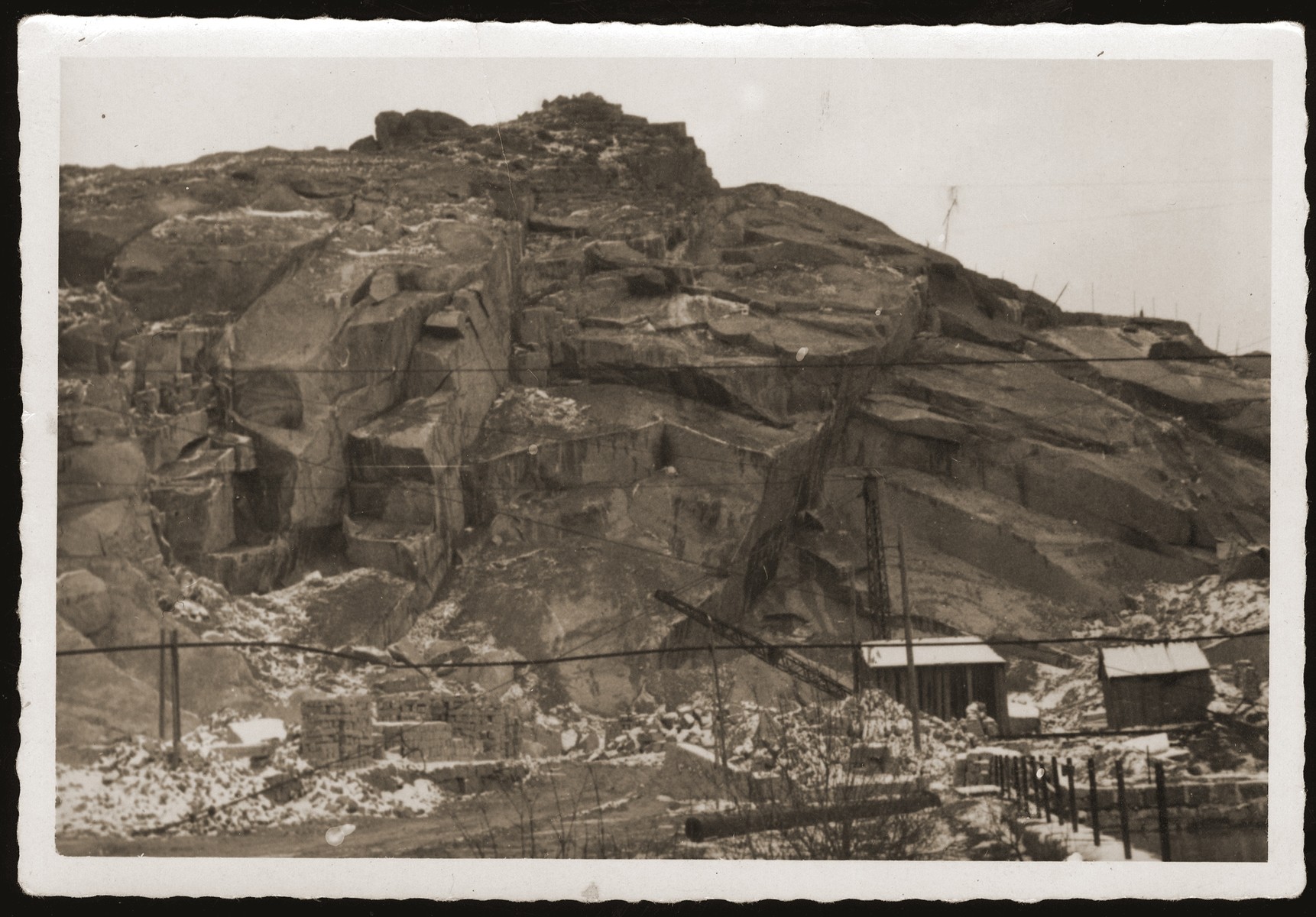 View of the quarry at the Flossenbuerg concentration camp, taken during a return visit to the camp on the first or second anniversary of the liberation by Jewish DPs living in the city of Weiden, Germany.

During his incarceration in Flossenbuerg, the donor had been forced to work in the quarries, and had been seriously injured when he got caught between two hopper cars carrying materials from the site.