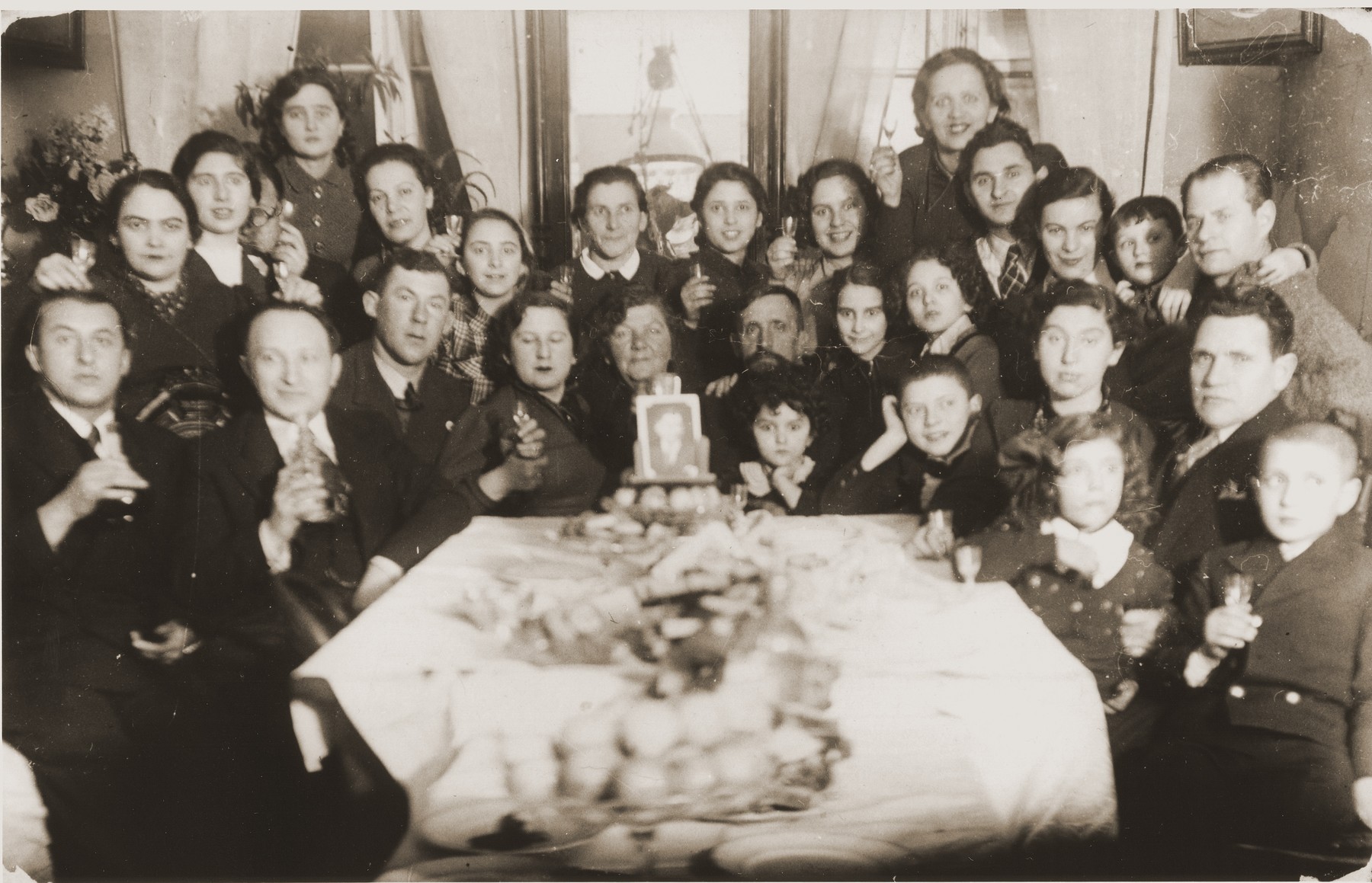 Family gathering to celebrate the marriage of Bezalel Mintz.  He had moved to Belgium and his photo appears on the center of the table.

Of those pictured only two survived.  From left to right those pictured include Benny Fil, Pola Fil, Ida Fil, Chayale Mintz, Rachel Danishevska, Devorah Danishevska, Syma Mintz Crane, Basel Danishevski, Sorele Mintz, Sashe Lepovski, Zirele Lepovski and Nemale Lepovski.