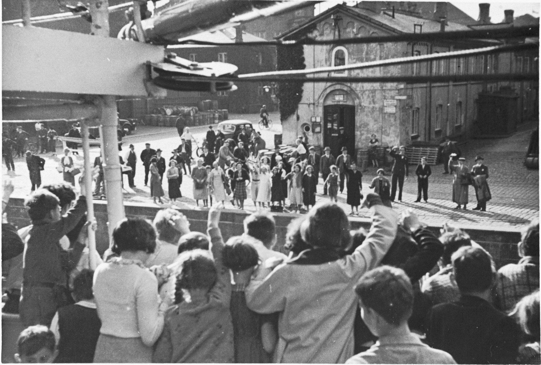 A group of Jewish children from Germany wave to their Danish hosts from the deck of the ship that is taking them home after their stay at a Kinderlager [children's recreational summer camp] in Horserod, Denmark. 
 
In 1935-36 Norbert Wollheim was involved in organizing groups of German Jewish youth to attend a summer camp in Denmark.