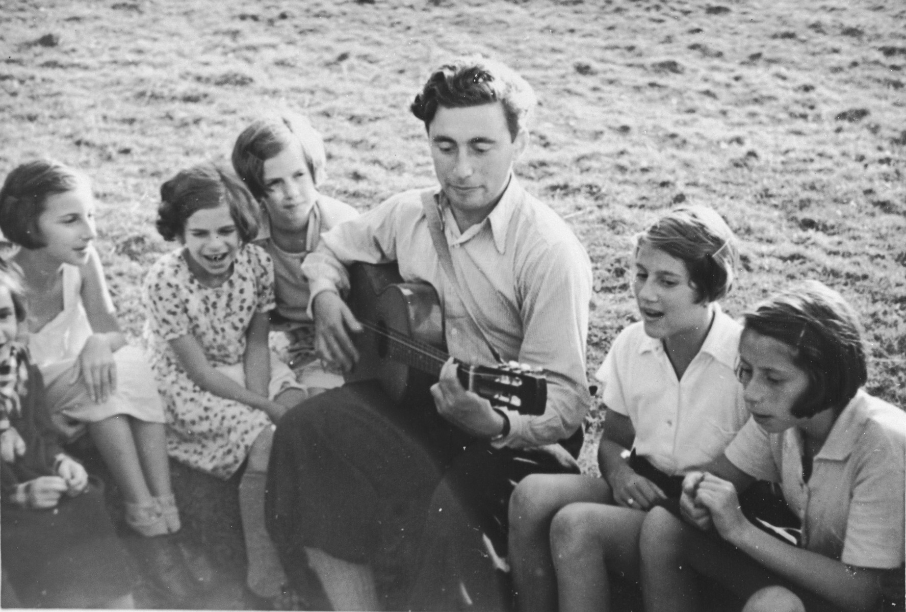 A group of Jewish girls from Germany sings along as one of their counselors play the guitar at a Kinderlager [children's recreational summer camp] in Horserod, Denmark. 
 
In 1935-36 Norbert Wollheim was involved in organizing groups of German Jewish youth to attend a summer camp in Denmark.