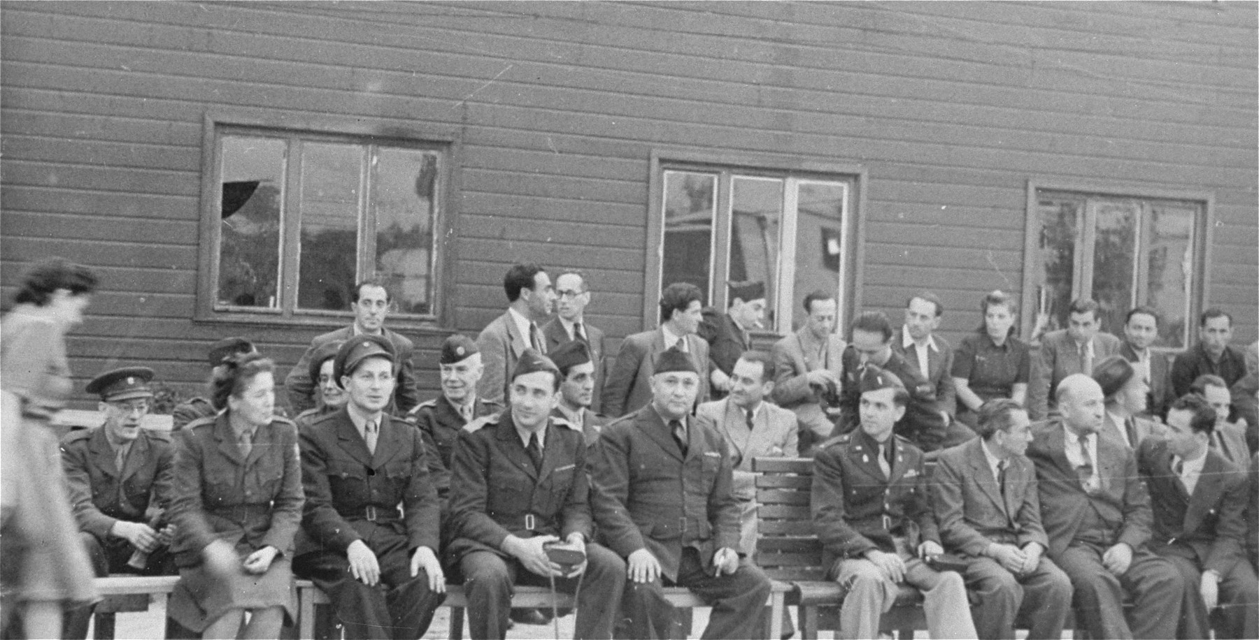 Officials of various agencies attend a ceremony at the Schlachtensee displaced persons camp in Berlin.  

Among those pictured in the front row are: Chaim Chonowitz of the Jewish Agency for Palestine (second from the left); Eli Rock, JDC director for Berlin (third from the left); Harold Fishbein, UNRRA director of the Schlachtensee camp (fourth from the left); Chaplain Mayer Abramowitz (fifth from the left) and Szwartzberg, president of the central committee of Schlachtensee.