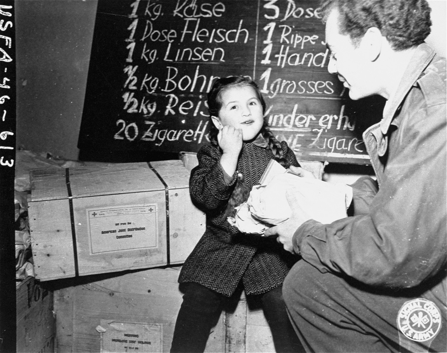 Harry Weinsaft of the American Jewish Joint Distribution Committee, gives food to three-year-old Renati Rulhater, a Jewish DP child in Vienna.  The campaign to distribute food to needy refugees in Vienna is sponsored by the Jewish Joint Welfare Association of Vienna in conjunction with the JDC.