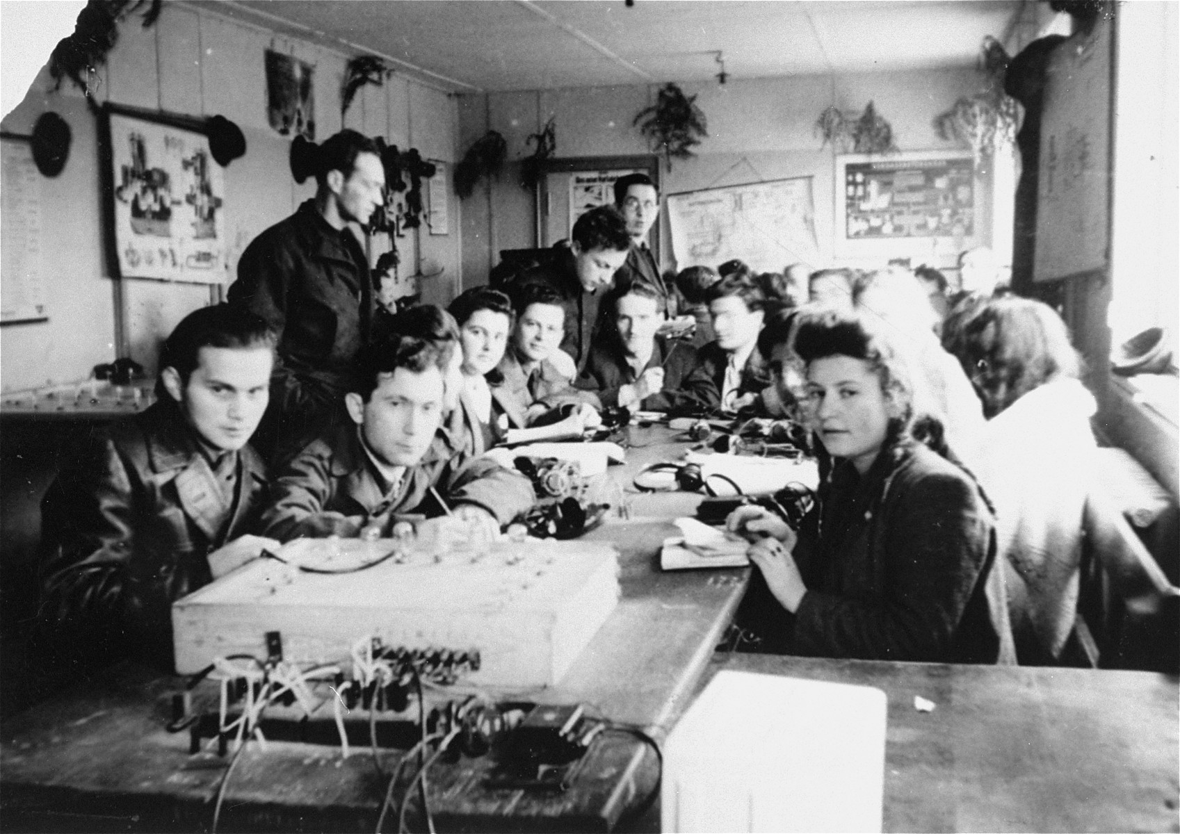 Young men and women attend a  radio telegraph class at the ORT school in the Schlachtensee displaced persons camp.  

Students pictured include Murka Bimbad, Lusia Gliklich, George Kupper, Abraham Wasserman, Icka Engelczyn, and ? Zycer.