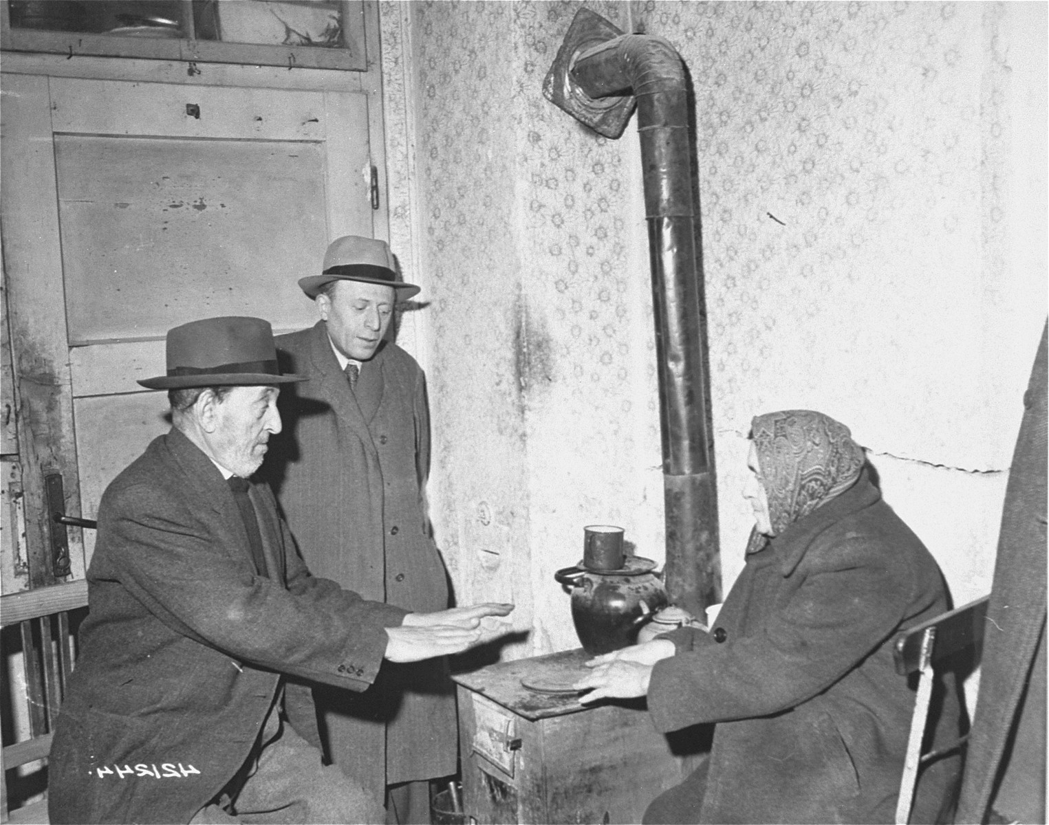 A Jewish DP family huddles around the stove which is used for heating and cooking at the Jewish DP camp located at Hallein, 15 miles from Salzburg.