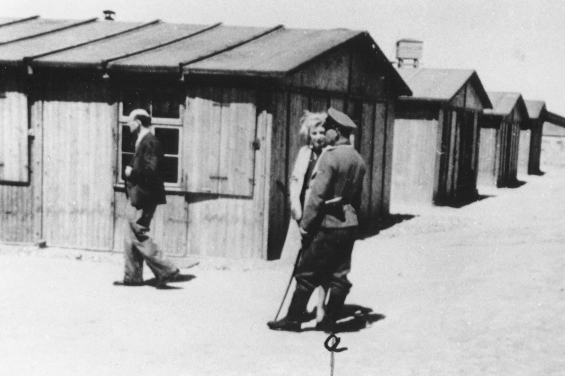 An SS officer identified as Lehnert converses with a woman on the main street of the residential camp in Trawniki.