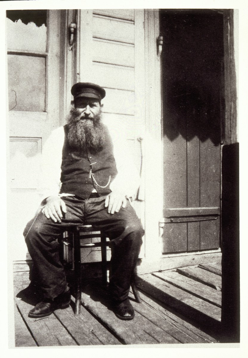 Reb Dovid "der Kichier" Moszczenik sits on the porch in front of his house on Mill Street. 

Reb Dovid, controlled and distributed all of the funds sent by the Detroit branch of the Eishyshker society from the late 1920s until his death in the '30s.