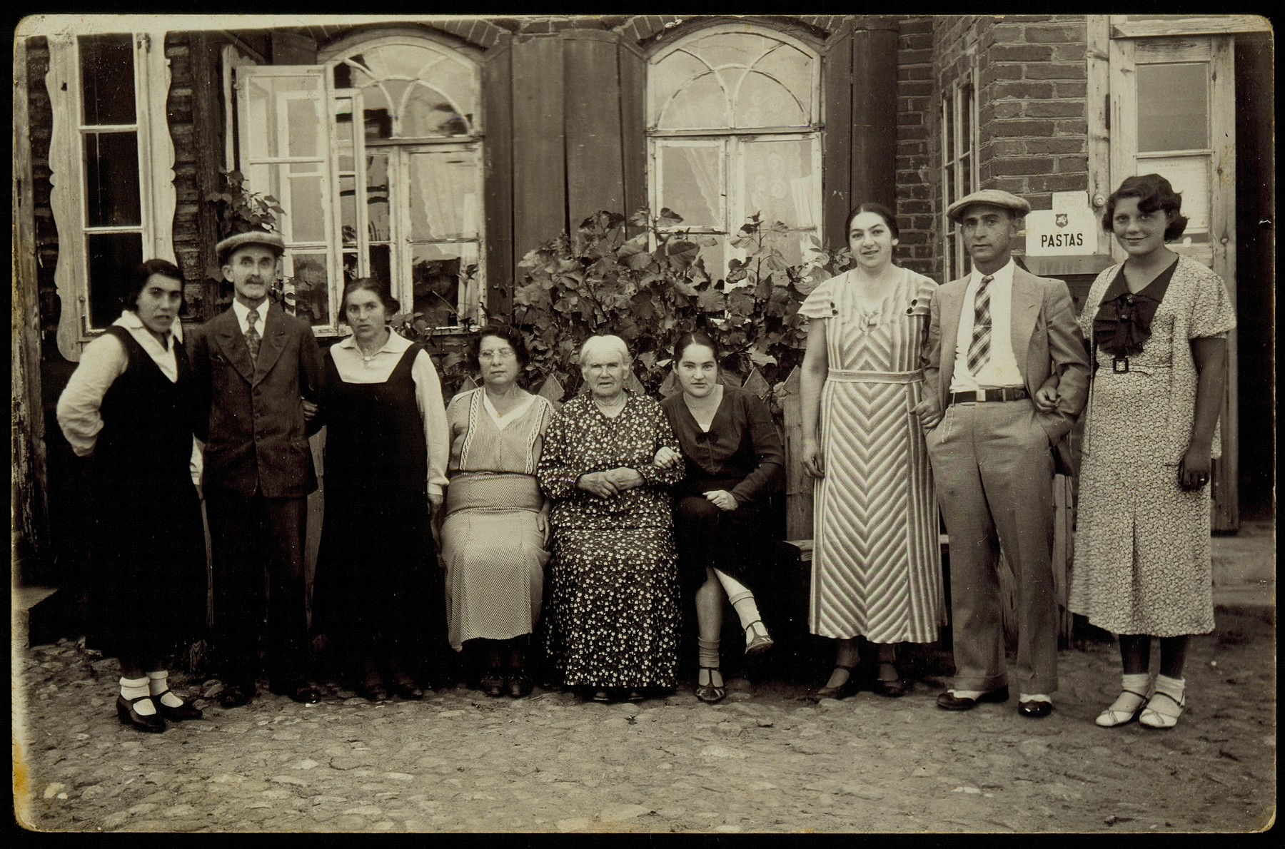 Members of the Zlotnik family gather in Aran on the occasion of a return visit by Yehuda-Leib Zlotnik from America.  

From left to right: Frieda Shoob, Hirsh Pruser, Fradl, Kunie's sister and mother of Roslyn Kablin, Bertha Margolis, a U.S. citizen, Mirl Resnik, Kunie Zlotnik's mother, Shifra, Kunie's sister, Kunie Resnik Zlotnik, husband, Yehuda-Leib Zlotnik, Gladys Ball, Bertha Margolis' daughter, a U.S. citizen. 

Mirl Resnik and her daughter Fradl were murdered by Lithuanians.  Shifra and her husband and three children were murdered in their home by the Germans in retaliation for the shooting of a German soldier while riding a motorcycle in the vicinity.  Kunie and Yehuda Zlotnik immigrated to Palestine.