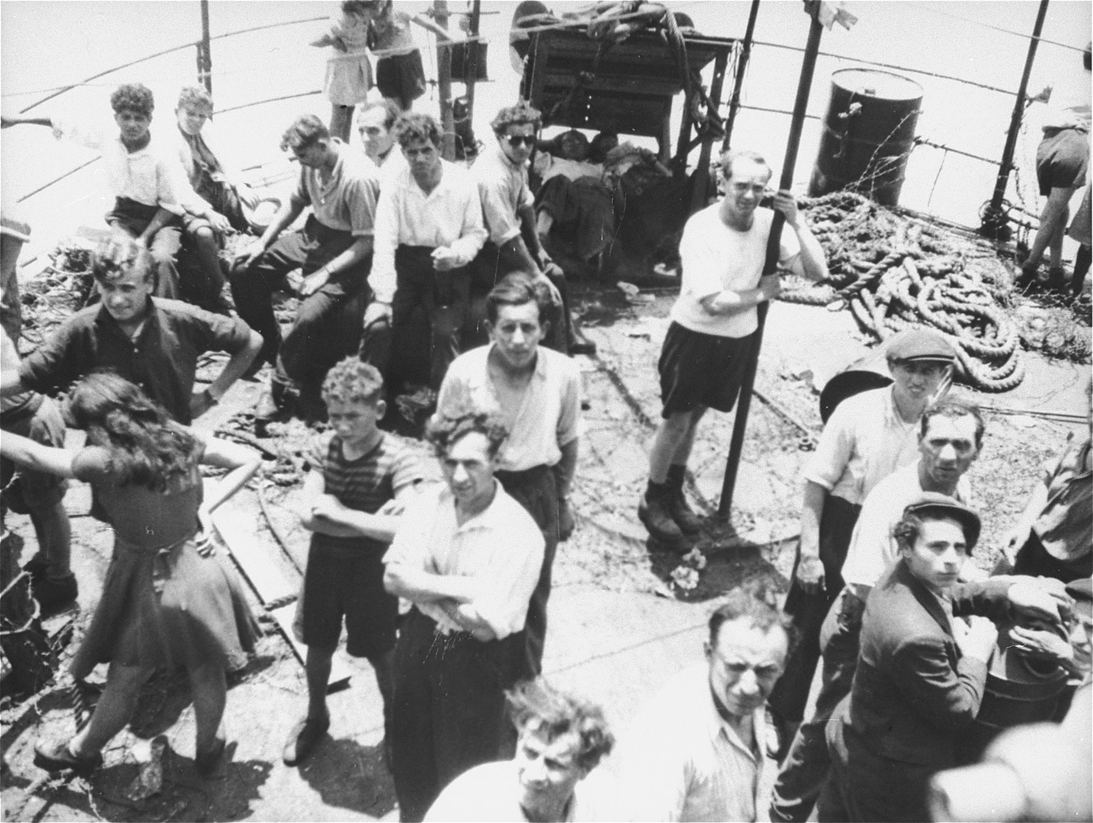 Jewish passengers stand on the deck of the Exodus 1947 amidst the debris from the previous night's struggle.