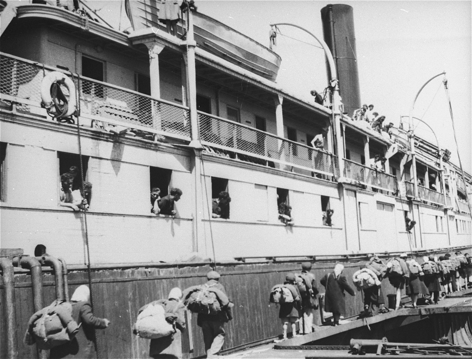 Exodus 1947 refugees board the President Warfield, docked at a quay in Sete's harbor, from a neighboring boat.