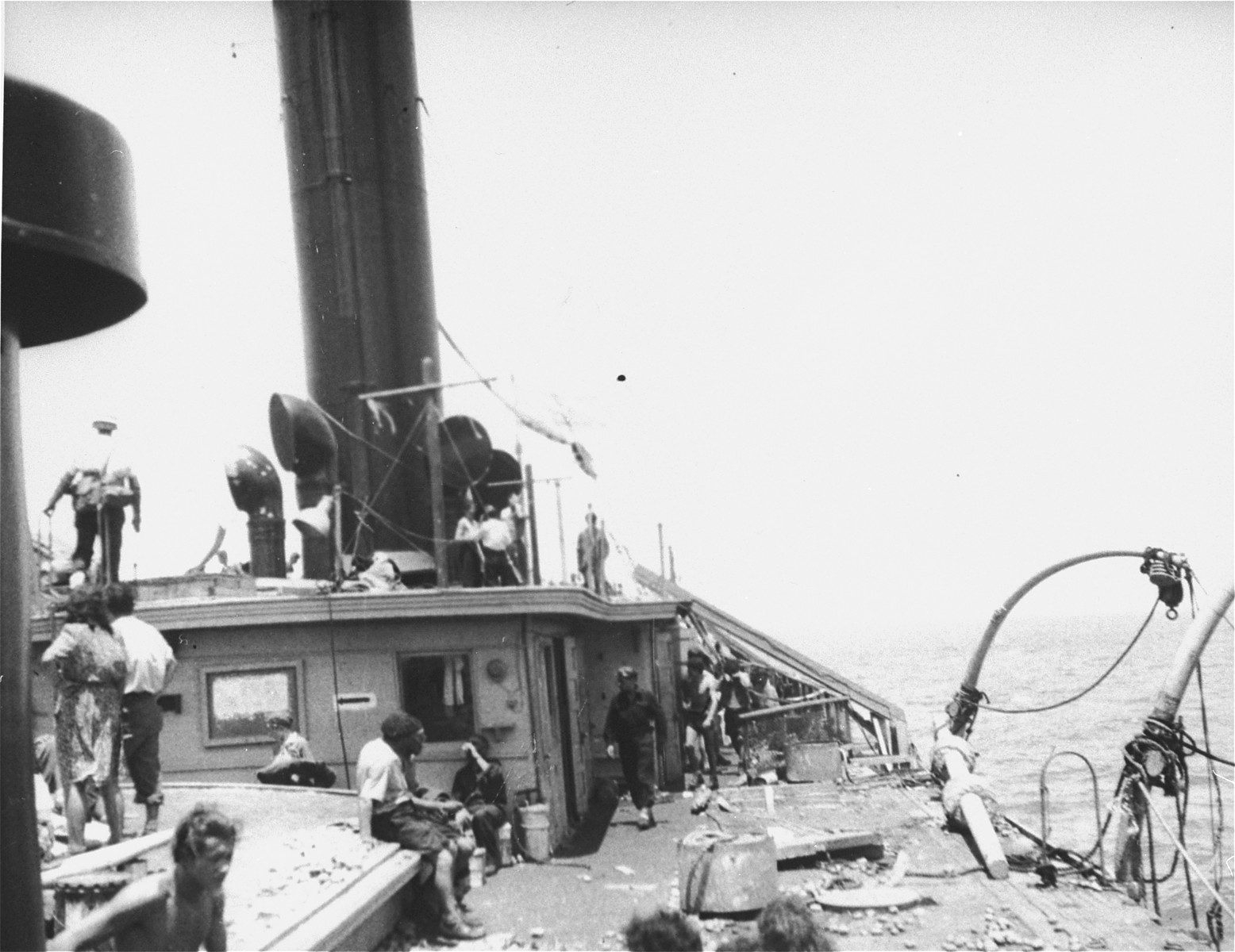 Jewish passengers stand on the deck of the Exodus 1947 amidst the debris from the previous night's struggle.