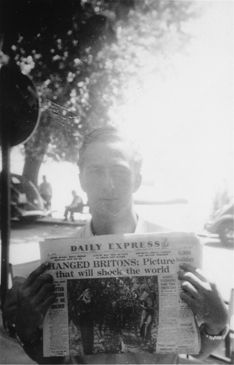 Former Exodus 1947 crew member Murray Aronoff, displays the headlines of a British newspaper reporting on the impact of the British interception of the illegal immigrant ship off the coast of Haifa.