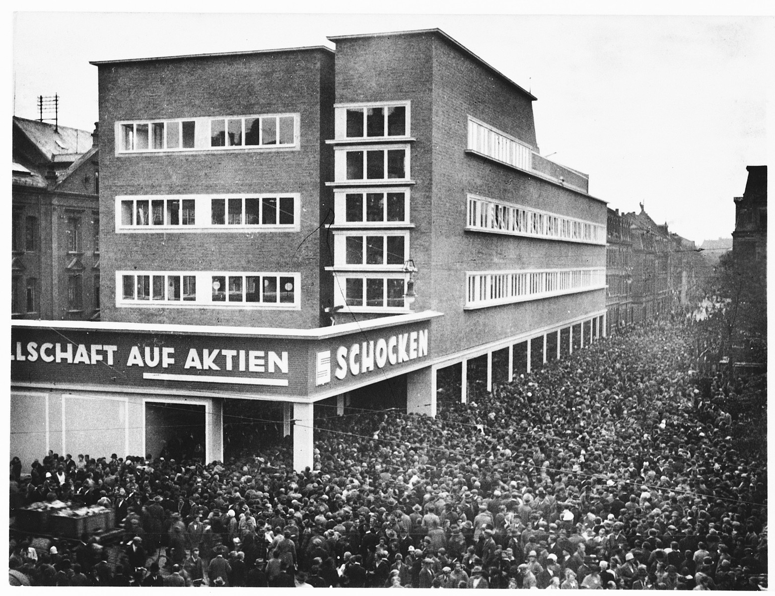 A huge crowd of people gather outside the Schocken department store in Nuremberg, Germany.