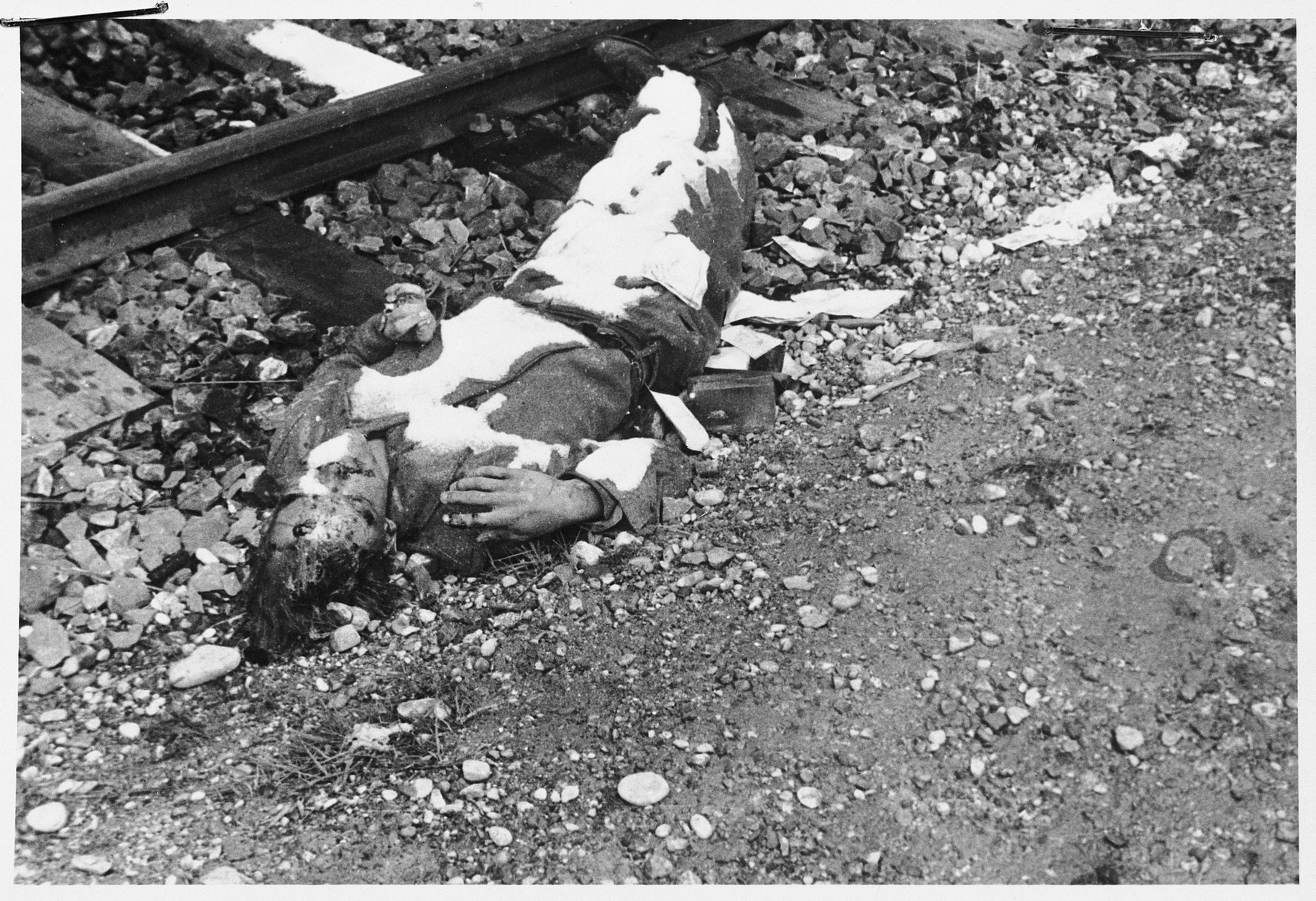 Close-up view of the corpse of an SS guard lying by a train track after he was killed in a revenge killing in Dachau.