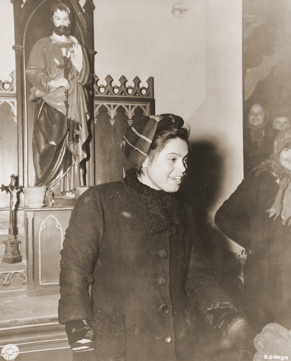 Twenty-year-old Nina Kalmykowa, from Schilowgrad, Russia, poses in a Catholic church in Harperscheid after her liberation by American troops from a German tank factory camp in Harperscheid, where she had been a slave laborer for two years.