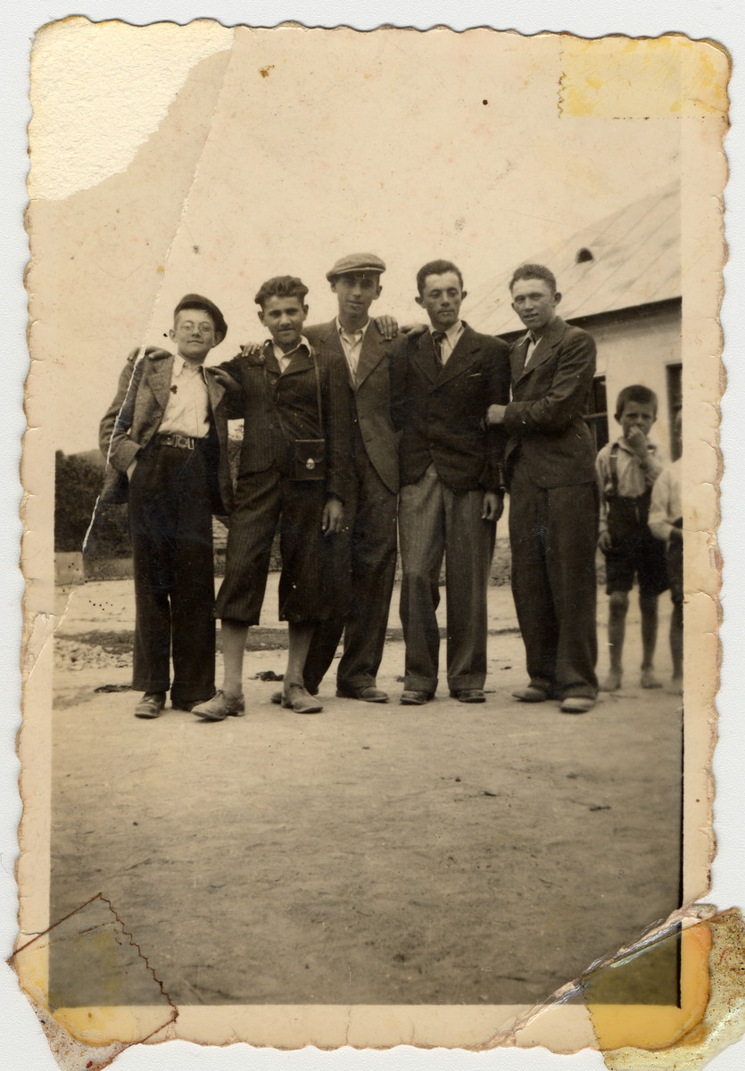Group portrait of Jewish teenagers standing outside a home in Mukachevo.

Among those pictured are Menachem Monush Kallus (right), brother of the donor and his cousin Chaim Neugreshel (center).
