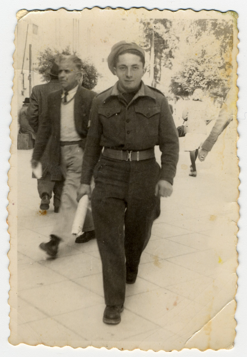 A recent immigrant walks down a street in Tel Aviv in his army uniform.

Pictured is Josef Fischer.