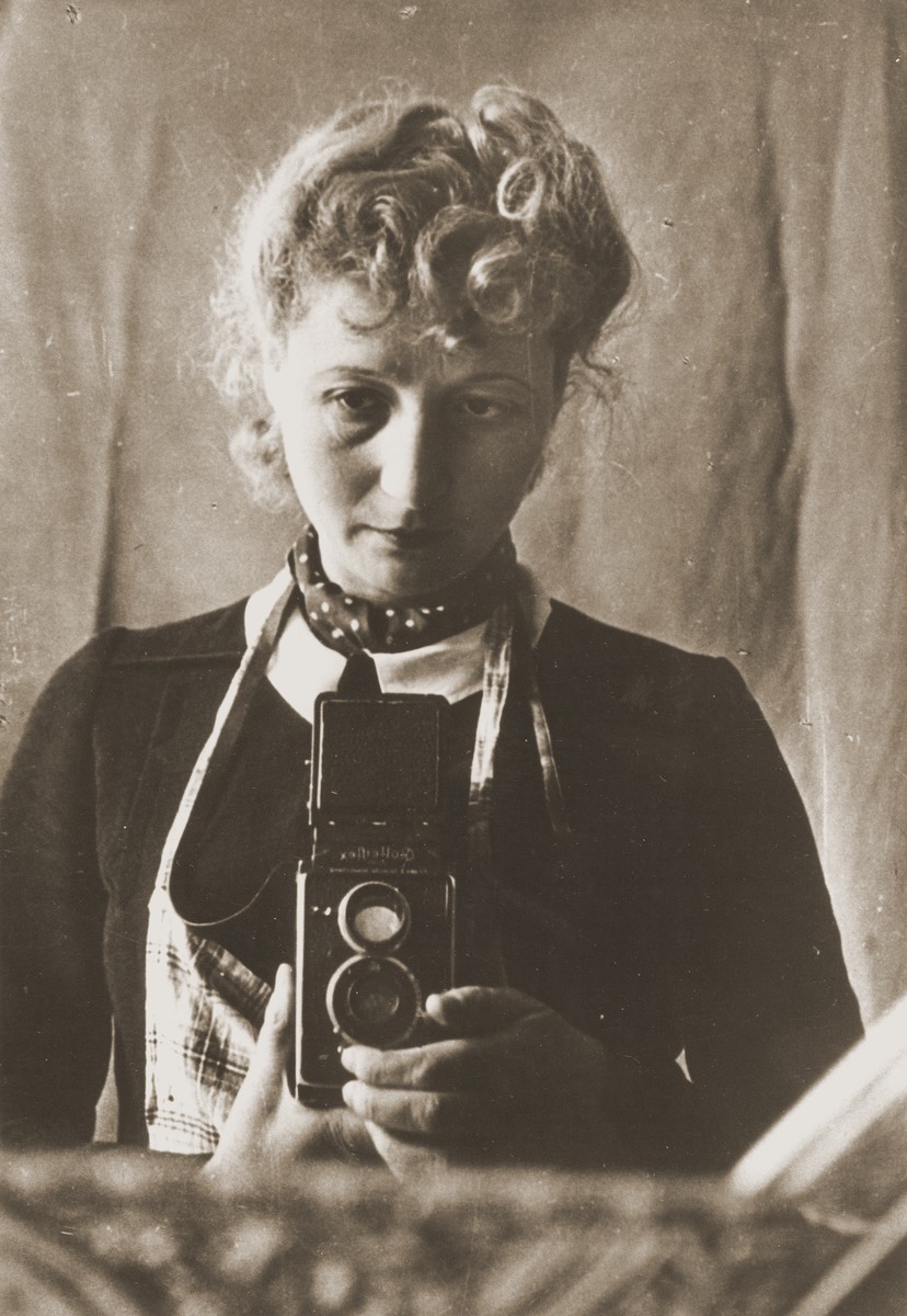 Self-portrait of photographer Julia Diament Pirotte in Marseille.

Julia Diamant Pirotte grew up in a working class Jewish family in Warsaw.  As a young woman in the 1930s she emigrated to Belgium, where she married and studied photography.  After the German occupation of Belgium and the deportation of her husband, Pirotte made her way to southern France.  There she played an active role in Jewish and French resistance groups.  Based in Marseilles, where she was employed as a photo journalist by Dimanche Illustre, Pirotte served as a courrier of weapons, false papers and underground publications.  In addition, she took numerous photos documenting life under the Vichy regime.  In 1943 she smuggled out to the United States a photographic report entitled "France under the Occupation," some of which was published in American periodicals.  As a member of the FTP, Francs-Tireurs et Partisans, she was able to photograph the activities of the Maquis resistance in the summer of  1944 and the final liberation of Marseilles.  After the war Pirotte worked as a photo journalist for the Polish periodical Zolnierz Polski.  During that period she  covered the Kielce Pogrom of July 4, 1946 and its aftermath.