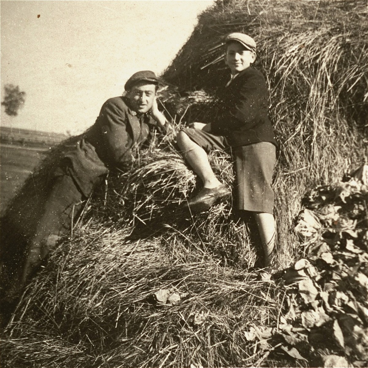 Two Jewish youth sit on a haystack in the Kolbuszowa ghetto.

Pictured are Manius Notowicz and his friend Mondi Stub.