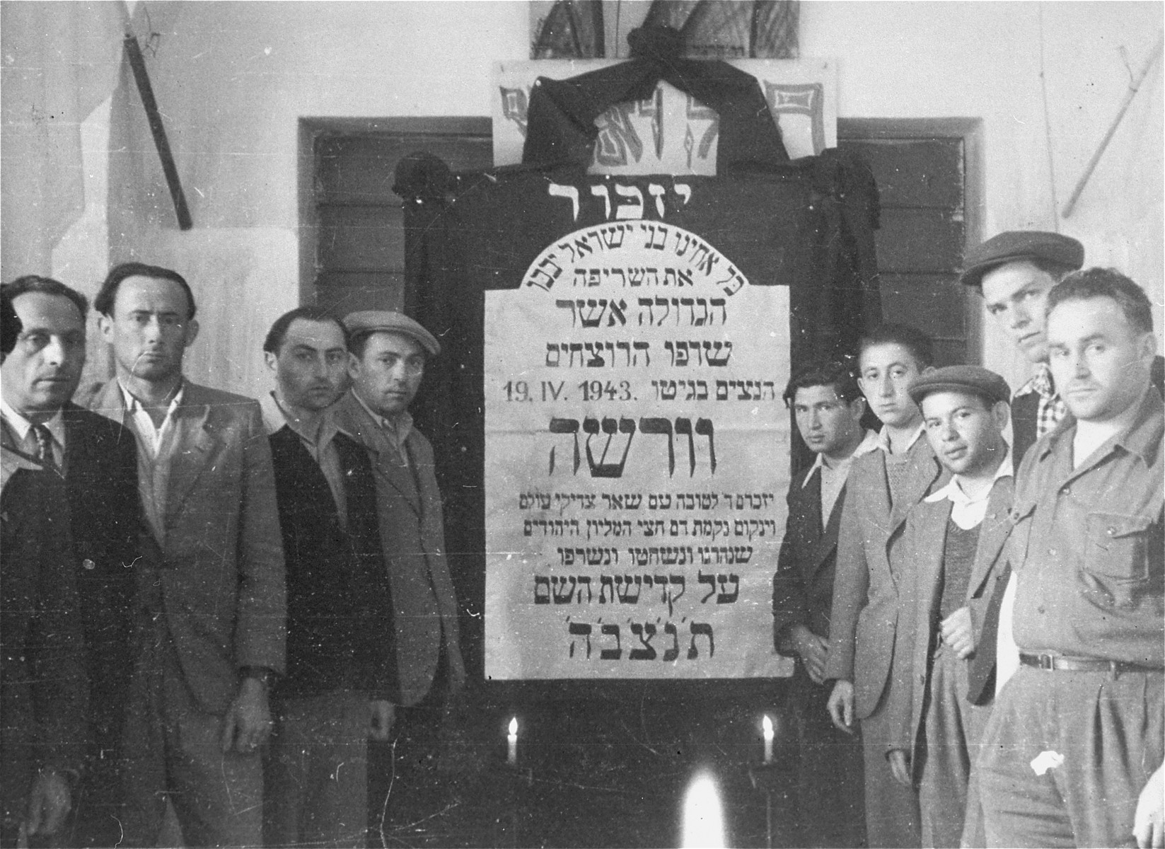 Jewish DPs in Cremona, Italy, gather around a plaque memorializing Jews who were killed by the Nazis during the suppression of the Warsaw ghetto uprising.

Among those pictured (fourth from the left) is Szepsel Kaftanski (later Seymore Kaftan).
