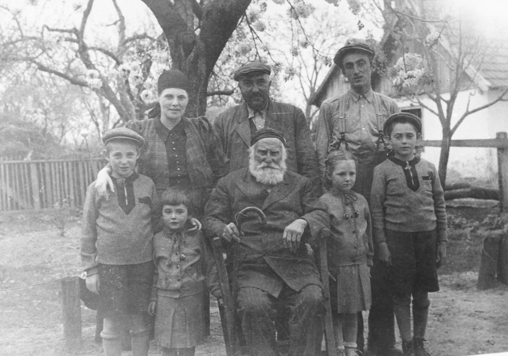 The Farkas family poses in the backyard for a family portrait taken by a visiting uncle from America.

Pictured front row (left to right) are Zoltan Farkas, Judit Farkas, Yaakov Koppel Farkas, Eva Farkas, and Erwin Farkas.  In the back row are Frieda Frankel, Jeno Farkas, and Sholom.