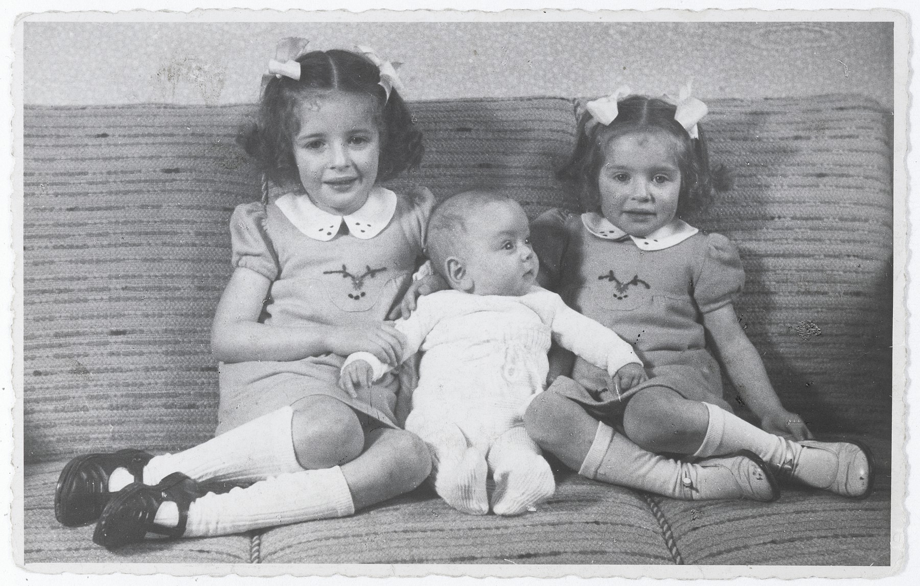 Three Jewish siblings pose on a sofa in their home in The Hague.

Pictured from left to right are Eva, Alfred and Leana Münzer.  The two girls later perished in Auschwitz.