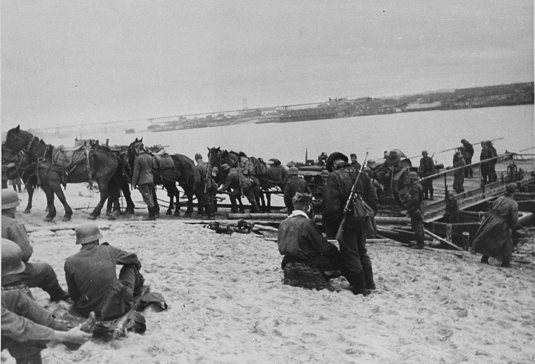 SS troops with the "Wiking" Division unload artillery brought across a river by barge.