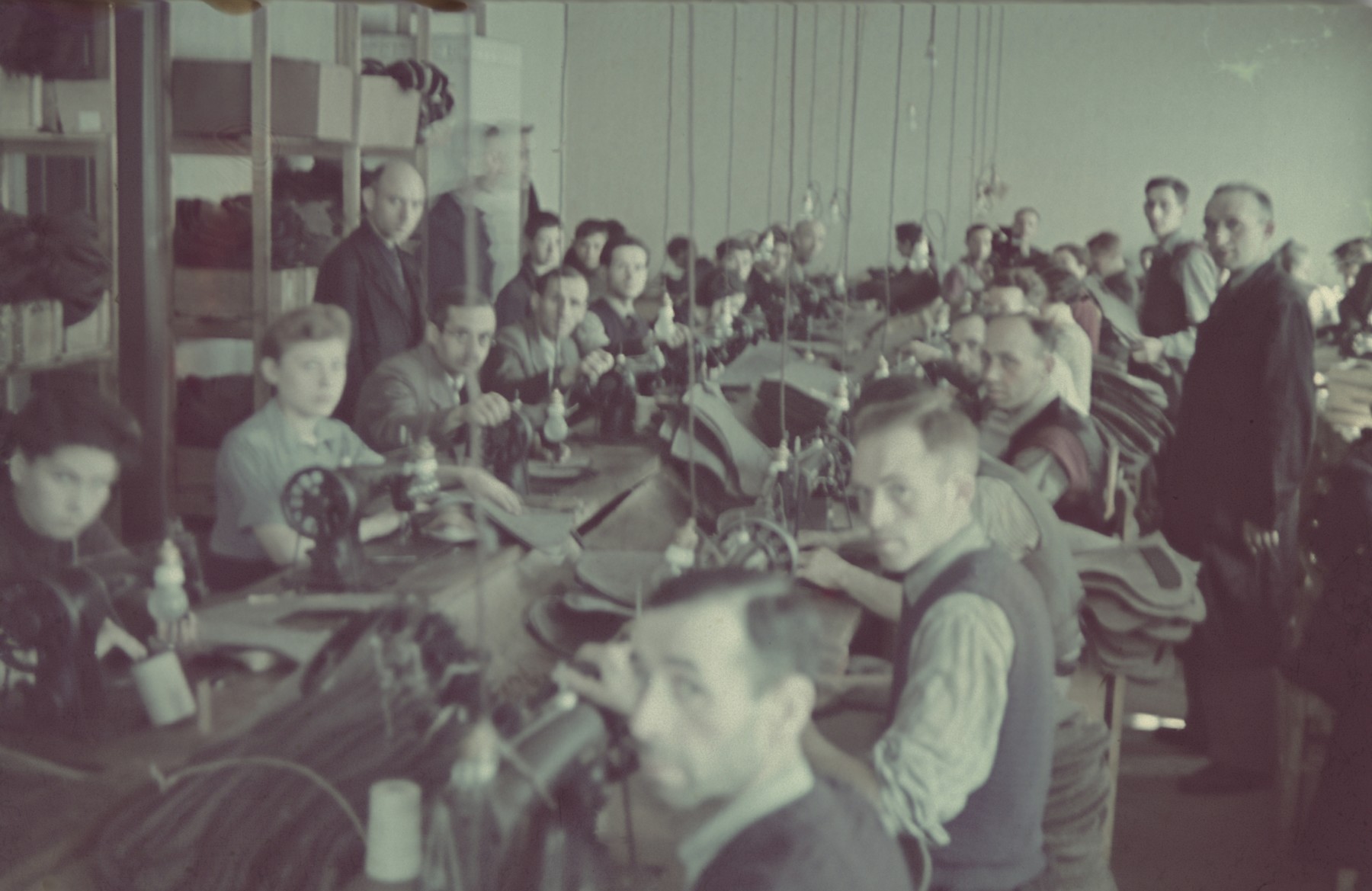 Workers operate sewing machines in the saddle-making workshop of the Lodz ghetto.

Original German caption: "Litzmannstadt-Getto, Sattlerei" (saddlery).